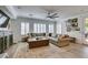 Comfortable living room featuring a plush sofa, decorative rug, and natural light from large windows at 7349 Royal Melbourne Dr, Las Vegas, NV 89131