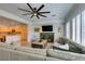 Bright living room with hardwood floors, a large sofa, and an open view to the kitchen area at 7349 Royal Melbourne Dr, Las Vegas, NV 89131