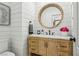 Charming bathroom with marble countertops, wood vanity and round mirror at 7566 Hope Valley St, Las Vegas, NV 89139