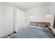 Modern bedroom with white wood-paneled walls, natural light, and minimalist design for a calming ambiance at 7566 Hope Valley St, Las Vegas, NV 89139