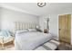 Sunlit bedroom features a bed with a tufted headboard, leading to an ensuite bathroom for convenience at 7566 Hope Valley St, Las Vegas, NV 89139