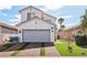 Two-story home with a gray garage door, artificial grass, and a brick driveway at 7566 Hope Valley St, Las Vegas, NV 89139