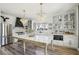 Bright, airy kitchen with an island, white cabinets, marble countertops and modern lighting fixtures at 7566 Hope Valley St, Las Vegas, NV 89139