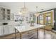 Bright, airy kitchen with a marble island, white cabinets, and doors leading to the backyard patio at 7566 Hope Valley St, Las Vegas, NV 89139