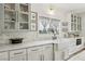 Bright, airy kitchen with white cabinets, marble countertops, apron sink, and marble backsplash at 7566 Hope Valley St, Las Vegas, NV 89139