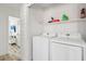 Efficient laundry room with side by side washer and dryer and a storage shelf at 7566 Hope Valley St, Las Vegas, NV 89139