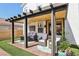 Backyard patio with a pergola, seating area, artificial grass, and brick pavers at 7566 Hope Valley St, Las Vegas, NV 89139