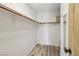 Simple walk-in closet with wood shelf and rail and wood-look floors, ready for personalized organization at 7566 Hope Valley St, Las Vegas, NV 89139