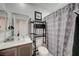 Functional bathroom with a vanity, toilet, shelving unit, and patterned shower curtain at 759 Pickled Pepper Pl, Henderson, NV 89011
