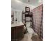 Bathroom with dark vanity, open shelving, and patterned shower curtain at 759 Pickled Pepper Pl, Henderson, NV 89011