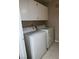 This laundry room has a washer, dryer, and overhead storage at 7885 W Flamingo Rd # 1064, Las Vegas, NV 89147