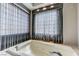 Modern bathroom features a luxurious jacuzzi bathtub beneath a large window, offering a relaxing and spa-like experience at 8121 Castle Pines Ave, Las Vegas, NV 89113