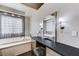 Bathroom features a vanity area, modern fixtures, and a luxurious soaking tub with views, creating a spa-like experience at 8121 Castle Pines Ave, Las Vegas, NV 89113