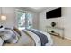 Comfortable bedroom with console table, wall-mounted television, and doors to the backyard at 8121 Castle Pines Ave, Las Vegas, NV 89113