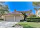 Charming home features a two-car garage, red tile roof, and mature landscaping at 8121 Castle Pines Ave, Las Vegas, NV 89113