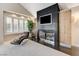 Modern bedroom features a stylish fireplace, a comfortable lounge chair, and a large window for natural light at 8121 Castle Pines Ave, Las Vegas, NV 89113