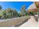 Relaxing covered patio area with views of lush landscaping and mature trees at 8121 Castle Pines Ave, Las Vegas, NV 89113