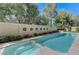 Sparkling swimming pool with a spa, set against a backdrop of lush greenery and a privacy wall at 8121 Castle Pines Ave, Las Vegas, NV 89113