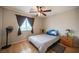 Traditional bedroom featuring a ceiling fan, window with drapes, and wood-look flooring at 8368 Creek Canyon Ave, Las Vegas, NV 89113