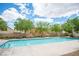 Relaxing community pool surrounded by lush landscaping and seating areas at 8368 Creek Canyon Ave, Las Vegas, NV 89113
