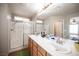 Well-lit main bathroom with dual sinks, long vanity, and a glass-enclosed shower at 8368 Creek Canyon Ave, Las Vegas, NV 89113