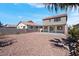 Wide view of the backyard with a covered patio and low-maintenance desert landscaping at 8725 Russet Hills Ct, Las Vegas, NV 89147