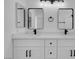 Modern bathroom features double vanity, white cabinets and black hardware at 8725 Russet Hills Ct, Las Vegas, NV 89147