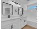 Modern bathroom features double vanity, white cabinets, tub and black hardware at 8725 Russet Hills Ct, Las Vegas, NV 89147