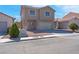 Attractive two-story home boasts a tidy front yard, spacious driveway, and an attached garage at 8725 Russet Hills Ct, Las Vegas, NV 89147