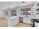 Open kitchen with stainless steel appliances, stone countertops, white cabinets, and backyard access at 8725 Russet Hills Ct, Las Vegas, NV 89147