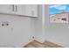 A bright laundry room with hook ups and upper cabinets by a sunny window at 8725 Russet Hills Ct, Las Vegas, NV 89147