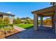 Well-maintained backyard featuring a manicured lawn, mature trees, and a covered patio area for outdoor living at 880 Cirrus Cloud Ave, Las Vegas, NV 89138