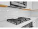 Stainless steel kitchen cooktop with white subway tile backsplash and white countertops at 880 Cirrus Cloud Ave, Las Vegas, NV 89138