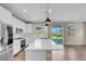 Spacious open-concept kitchen with white cabinets, stainless steel appliances, hardwood floors, and backyard access at 880 Cirrus Cloud Ave, Las Vegas, NV 89138