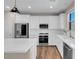 Modern kitchen with white cabinets, stainless steel appliances, quartz countertops, and stylish pendant lighting at 880 Cirrus Cloud Ave, Las Vegas, NV 89138
