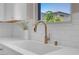 Close-up of a kitchen sink featuring white countertops, white backsplash and brass hardware at 880 Cirrus Cloud Ave, Las Vegas, NV 89138