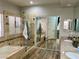 Well-appointed bathroom with double sinks, a glass-enclosed shower, and a soaking tub at 8928 Reining Spur Ave, Las Vegas, NV 89143