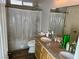 Well-lit bathroom with double sinks, granite countertop and a shower with curtain in a modern residence at 8928 Reining Spur Ave, Las Vegas, NV 89143