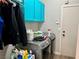 Functional laundry room with washer, dryer, blue cabinets, and storage solutions at 8928 Reining Spur Ave, Las Vegas, NV 89143