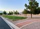 Serene community park with walking path, mature trees, and mountain views, creating a peaceful retreat at 8928 Reining Spur Ave, Las Vegas, NV 89143