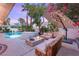 Inviting backyard oasis with pool, spa, fire pit, and comfortable seating under a shaded umbrella at 9615 Sedona Hills Ct, Las Vegas, NV 89147