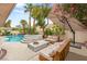 This home features a backyard retreat with a pool, spa, lush landscaping, and comfortable seating at 9615 Sedona Hills Ct, Las Vegas, NV 89147