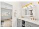 Bright bathroom with dual sinks, white countertops, gold hardware, and sleek gray cabinetry at 9615 Sedona Hills Ct, Las Vegas, NV 89147