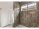 This sleek bathroom features a shower with modern gray tiling, gold fixtures, and a bright window at 9615 Sedona Hills Ct, Las Vegas, NV 89147