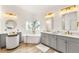 Contemporary primary bathroom featuring dual sinks, modern lighting, soaking tub and elegant decor at 9615 Sedona Hills Ct, Las Vegas, NV 89147