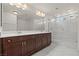 Bright bathroom showcasing a dual sink vanity, large mirror, and glass enclosed shower at 9742 Toad Hollow St, Las Vegas, NV 89141