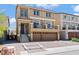 A view of a two-story home featuring a balcony, a two-car garage and a red tile roof, steps and landscaping at 9742 Toad Hollow St, Las Vegas, NV 89141