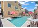 A backyard swimming pool and a jacuzzi are furnished with lounge seating and red umbrellas at 9742 Toad Hollow St, Las Vegas, NV 89141