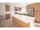 Bright, open kitchen with stainless appliances, light wood cabinets, an island and a seamless transition to other rooms at 9817 Kernville Dr, Las Vegas, NV 89134