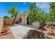 This backyard features a tree, a block wall, and a concrete patio with desert landscaping at 100 Woolman Rink Ave, Las Vegas, NV 89123